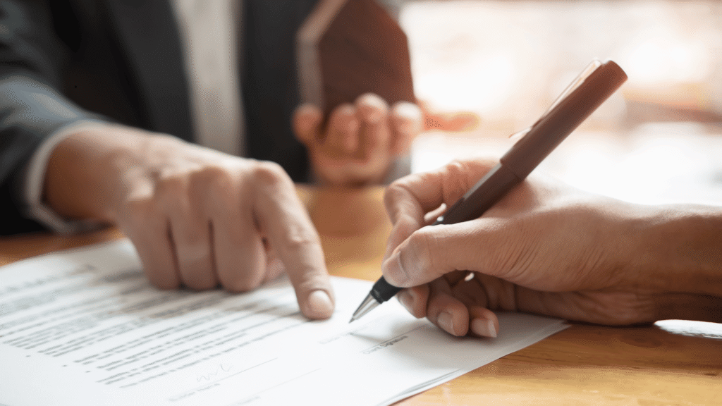 Una persona firmando un contrato de real estate
